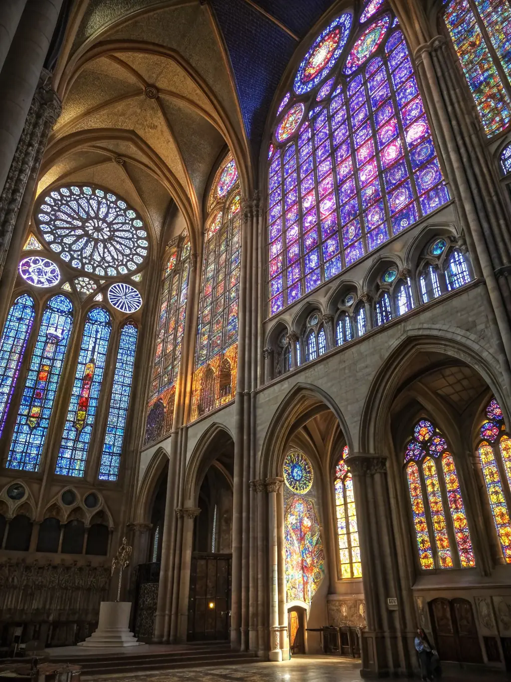 A photograph showcasing the Église de Recoules' newly restored stained glass windows, bathed in soft, natural light, highlighting the intricate details and vibrant colors.